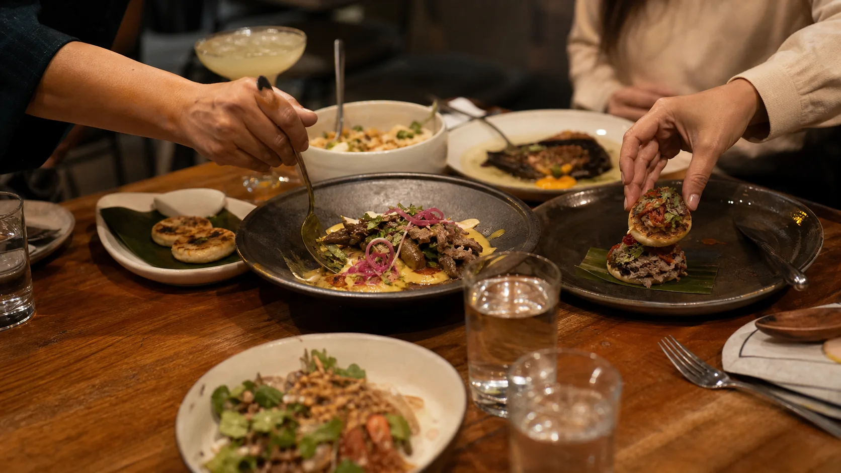 Mesa de restaurante en Medellín con platos colombianos contemporáneos para compartir